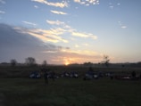 A peaceful sunrise over the retreat site, with yoga mats laid out on the grass.