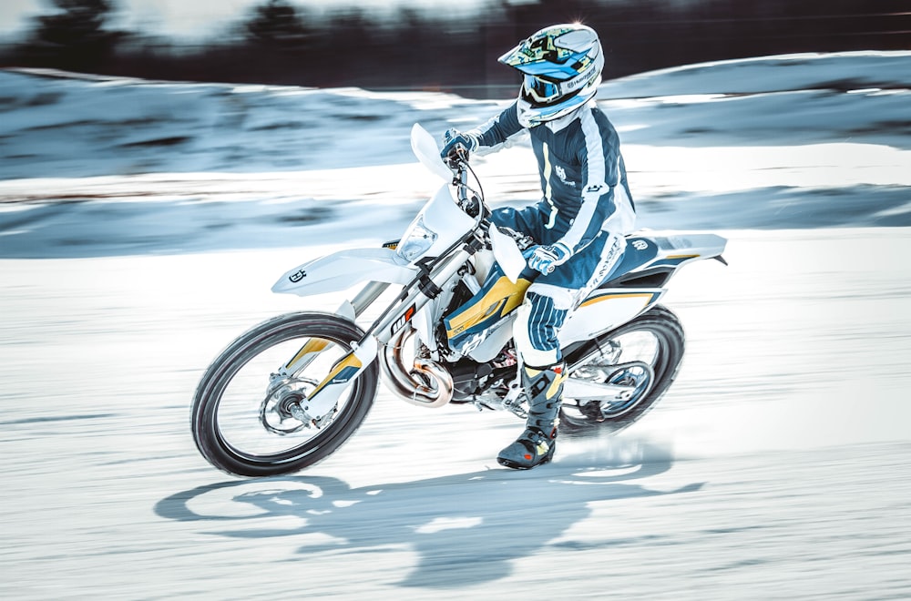 person riding on black and white motocross dirt bike