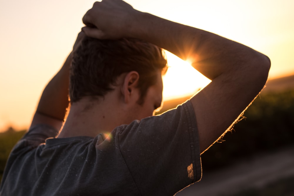 homme tenant ses cheveux contre la lumière du soleil