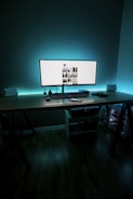 A web designer's workspace setup with a monitor displaying a web page portfolio.