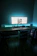 A modern workspace with a sleek desk setup illuminated by soft blue LED lights.