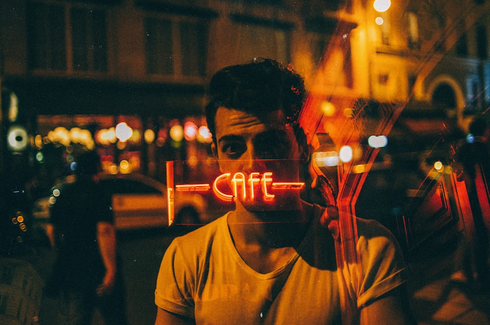 man looking on glass at nighttime