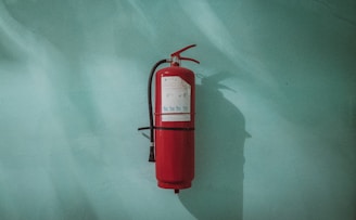 red fire extinguisher on green wall