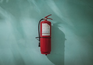 red fire extinguisher on green wall