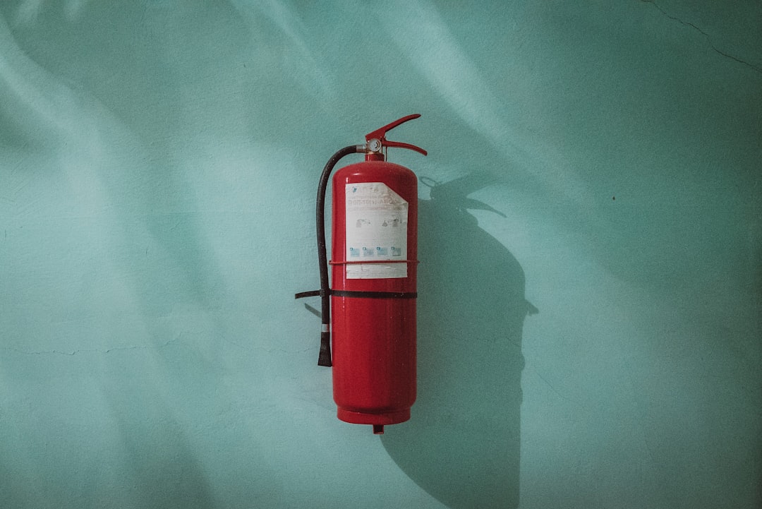 red fire extinguisher on green wall, Fire extinguisher