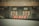 A close-up view of the back of a large vehicle, possibly a truck, with a set of red LED lights and a decorative panel featuring stylized eyes with orange and white diagonal stripes. The vehicle appears dusty, suggesting it has been used in a construction or industrial environment.