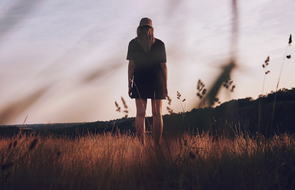 worm's view photography of woman standing on grass field