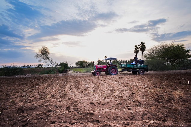 A vibrant farm scene showing researchers testing water-in-fuel emulsification technology on a tractor under a bright sky.