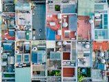 Aerial view of multiple rooftops with solar panels shining in the sunlight.