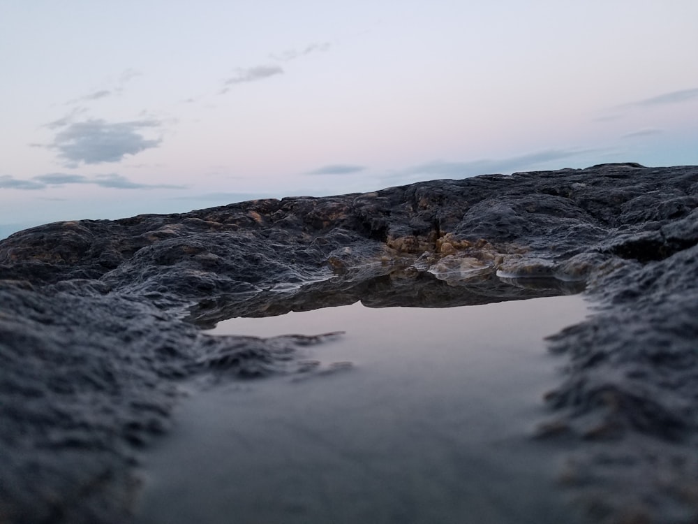 body of water near rock formation at night