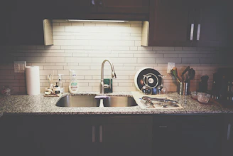 A stylish kitchen countertop featuring a polished kitchen sink and elegant taps.