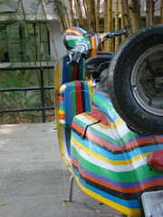 A vibrant photo showing a colorful scooter deck with custom graphics laid out on a workshop table