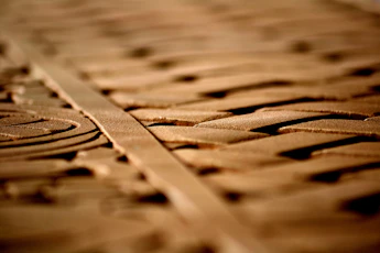 Close-up of ancient Lega symbols carved into wood, illuminated by soft natural light.