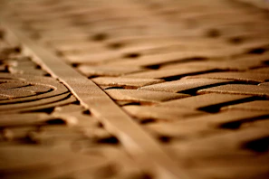 Artisan carving intricate patterns into a piece of natural wood under soft lighting.