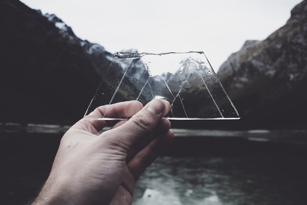 person holding clear glass panel