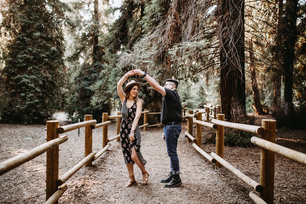 Homem e mulher dançando entre corrimãos de madeira marrom