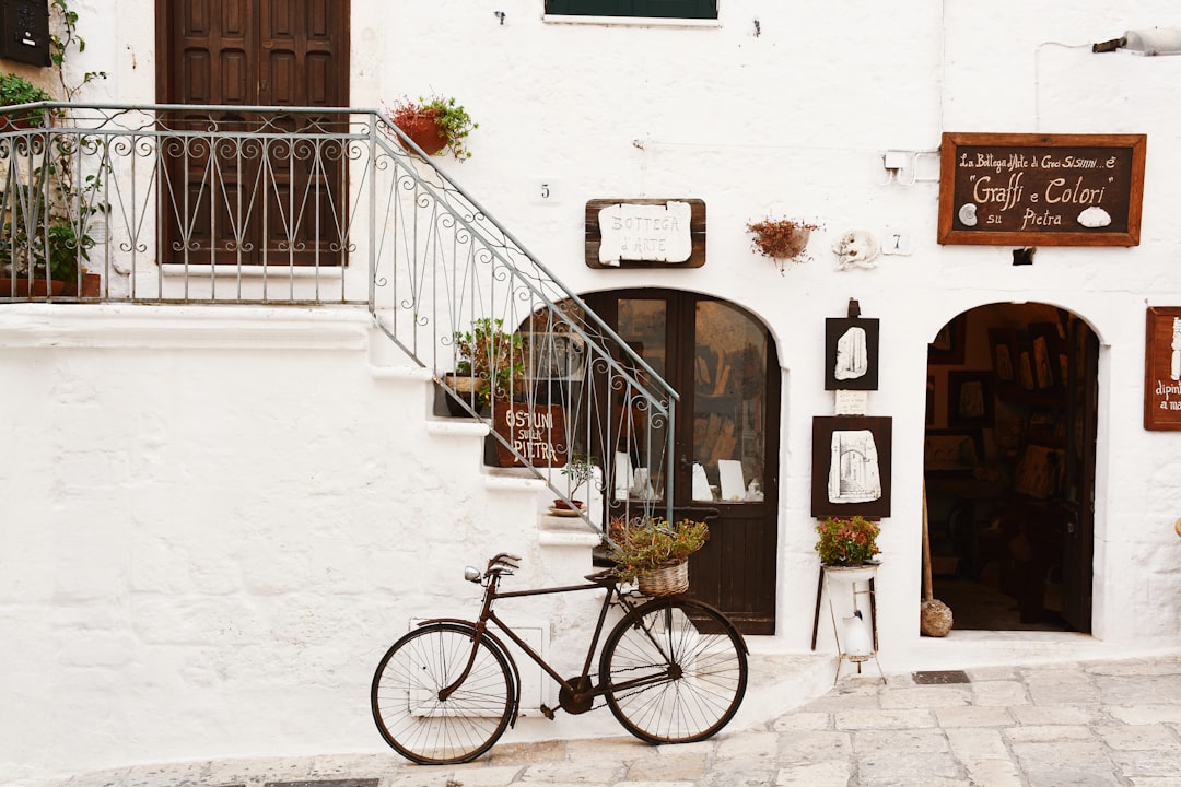 black bicycle near handrails at daytime, Vintage bike in front of restaurant in Italy