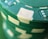 A close-up view of a stack of green poker chips with white accents and indented designs around the edges.
