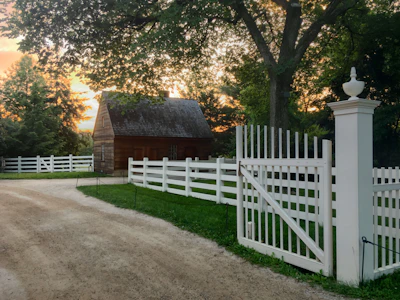 Cozy rustic gîte nestled among lush green trees at sunset.