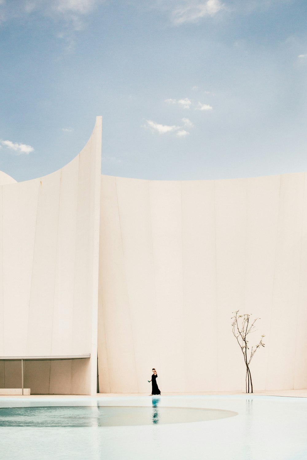 Mujer de pie frente a un edificio blanco