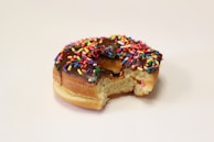 Close-up of a single mochi donut with a bite taken, showing its soft, chewy texture
