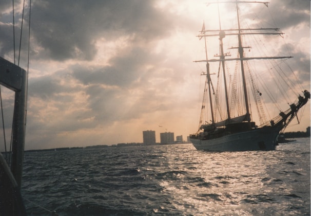 A vibrant painting of a majestic tall ship with billowing sails on a stormy sea.