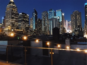 A cozy rooftop setup with string lights glowing softly against a twilight city skyline.