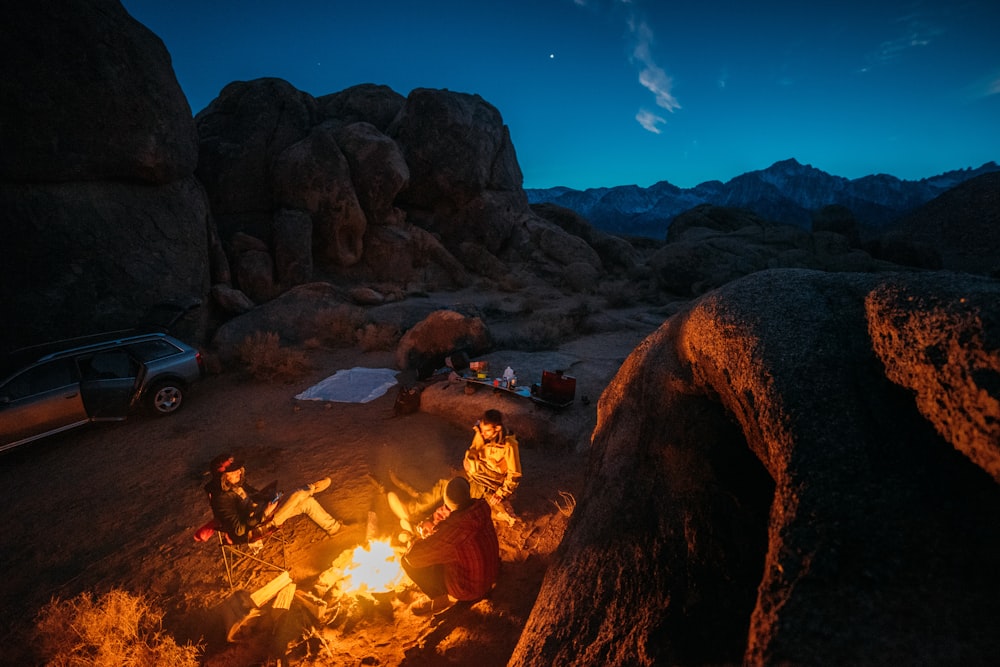 four people beside bonfire