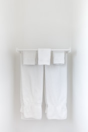 A plush, white bath towel folded neatly on a bathroom shelf.