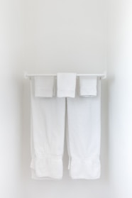A sturdy bathroom towel rack mounted neatly with fresh towels.