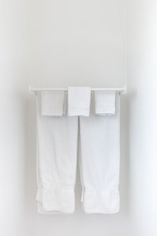 A plush, white bath towel folded neatly on a bathroom shelf.
