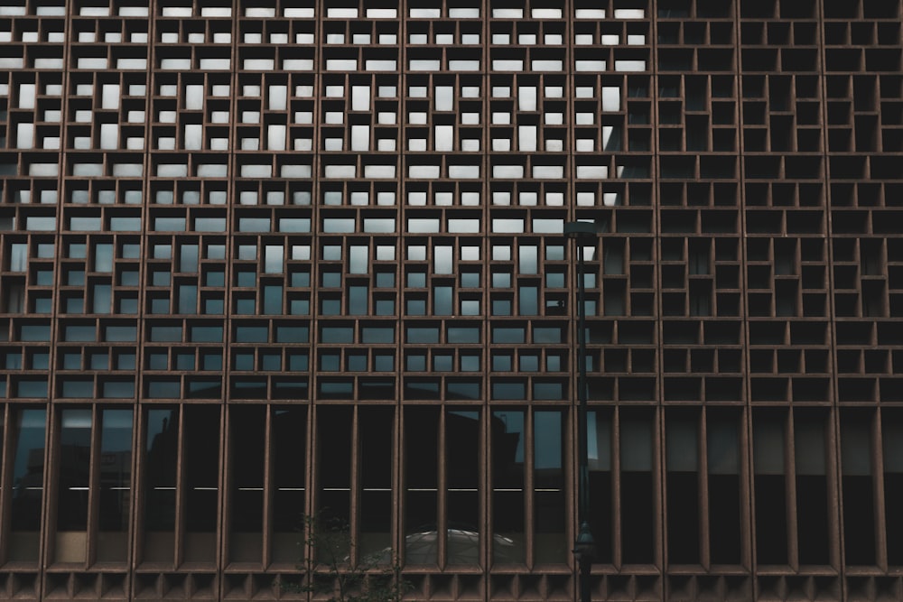 a close up of a metal fence with a building in the background