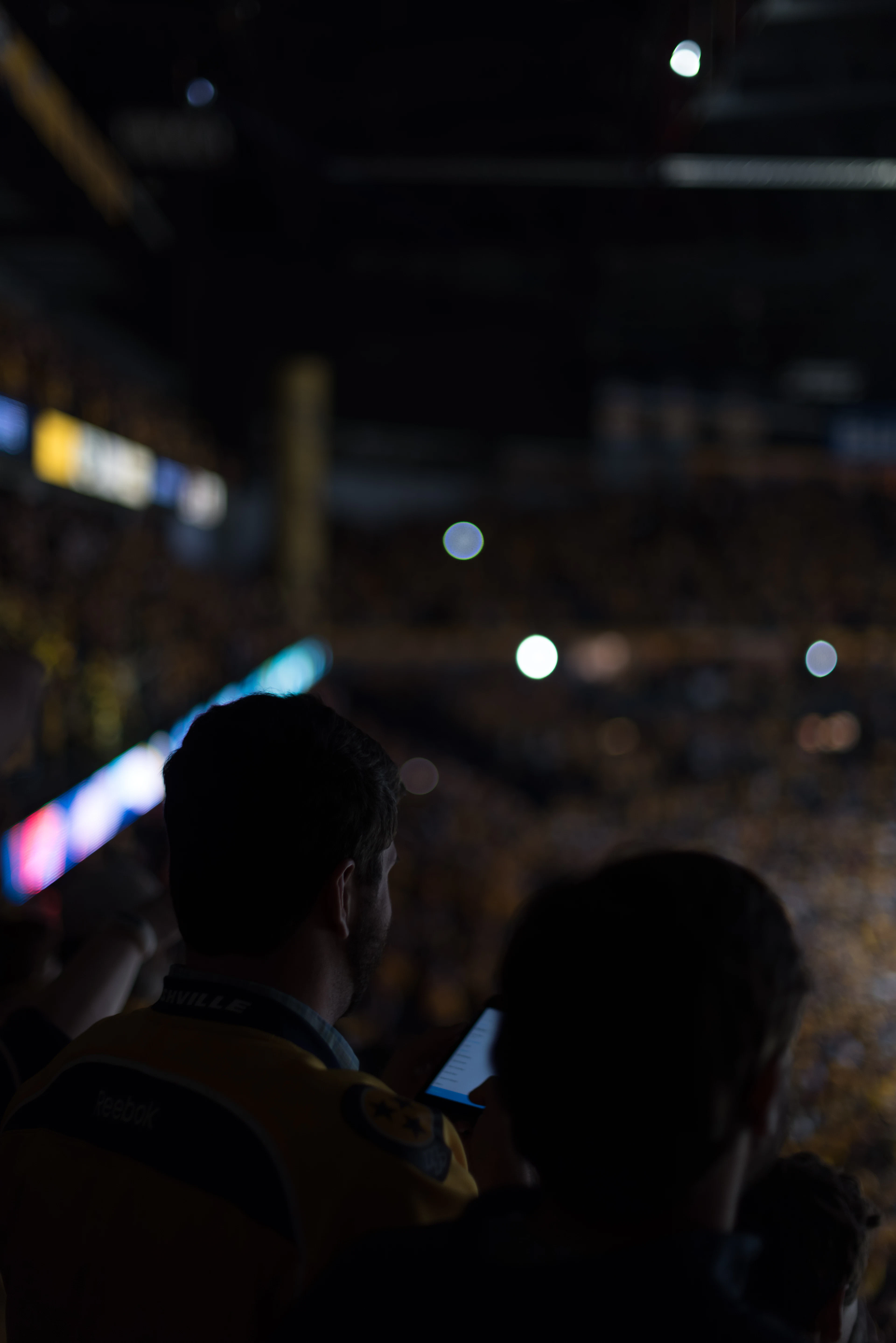 Fans in the stands under stadium lights