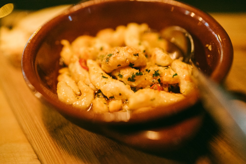 brown ceramic bowl with food