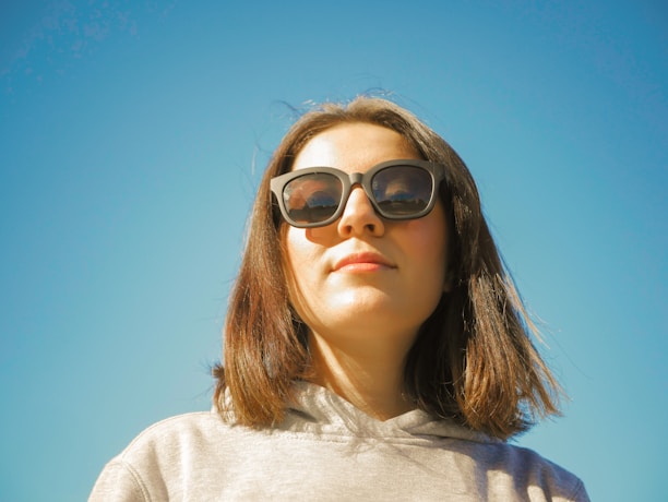 Close-up of a customer wearing a cozy black hoodie with sleek black sunglasses on a sunny day.