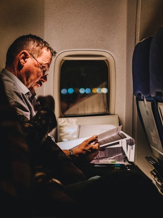 man reading book inside vehicle