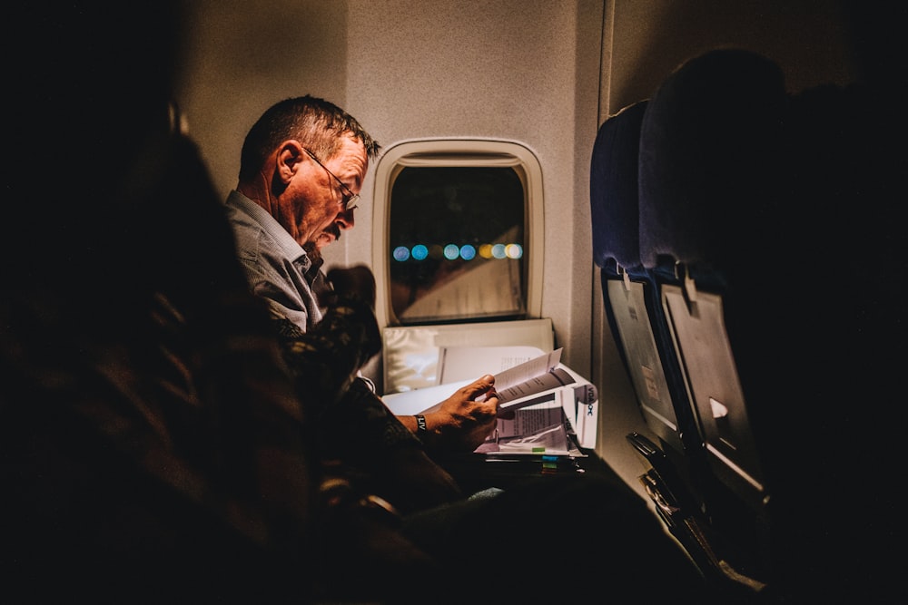 man reading book inside vehicle