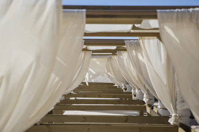 Waterproof linen curtains hanging gracefully with metal rings, gently swaying near a window on a breezy day.