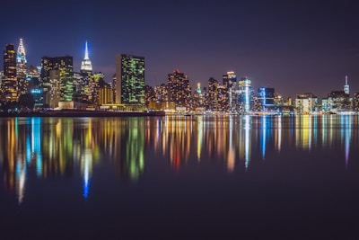 An artistic photo of a cityscape at night with colorful reflections.