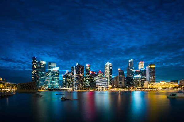 city buildings beside body of water under cloudy sky