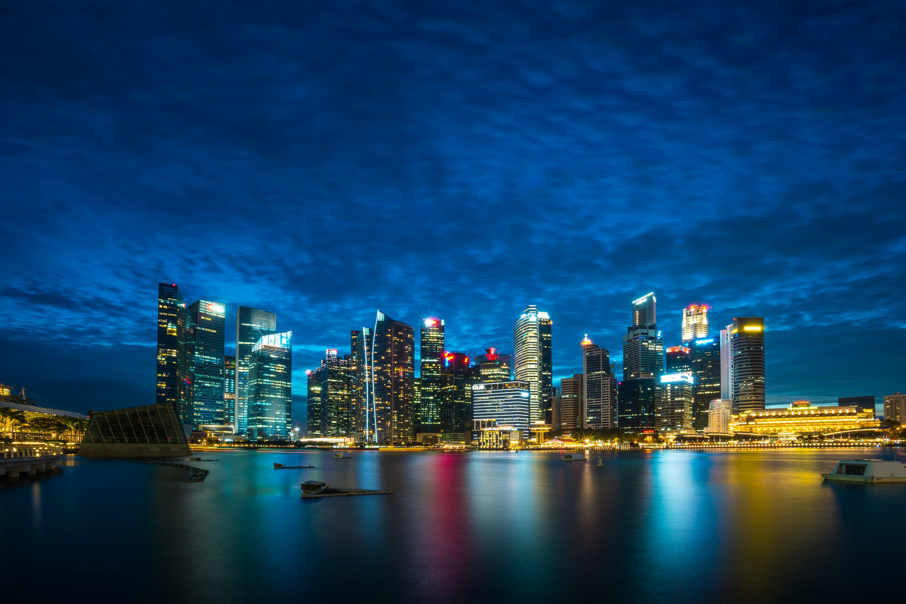 city buildings beside body of water under cloudy sky