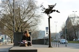 A young woman sitting on a bench, writing in a notebook.