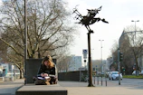 Young woman sitting in a park, jotting down notes about investing in government schemes.