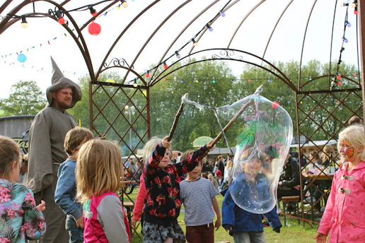 Friendly staff supervising children enjoying safe and joyful activities at the festival hub.