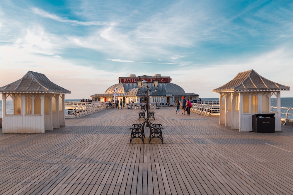 Bancos en el muelle de madera marrón bajo el cielo nublado durante el día