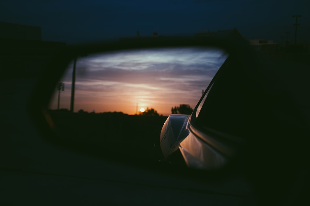 coucher de soleil orange sur le rétroviseur extérieur du véhicule