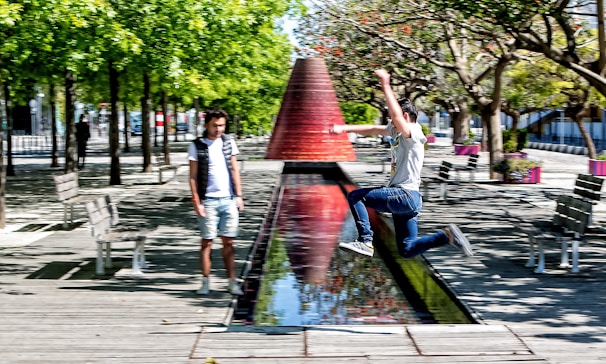 Instructor guiding a student through a precision jump in an outdoor park setting.