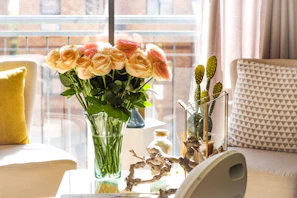 Cozy living room corner with pastel-toned ceramic vases holding fresh flowers, adding warmth.