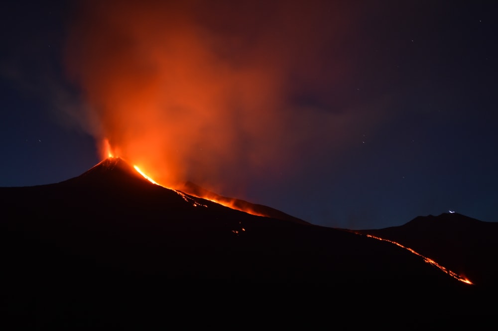 Montanha negra com lava fluindo à noite