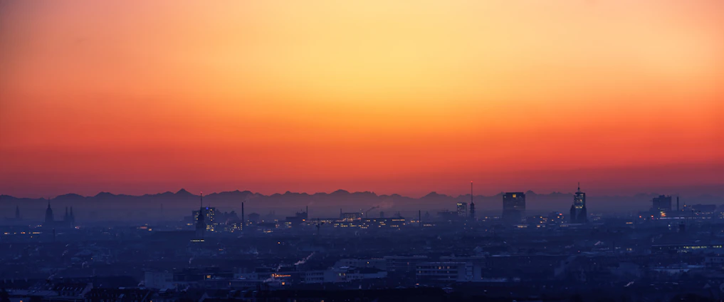 A panoramic view of Calgary's skyline blending into a vibrant Los Angeles cityscape at sunset.